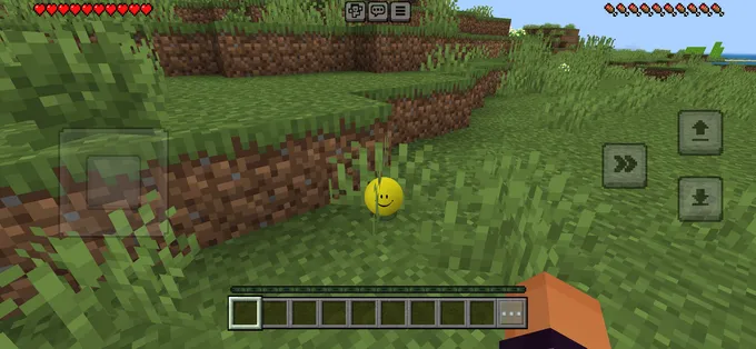Verity's yellow smiley-face orb sitting in the grass in Minecraft Bedrock